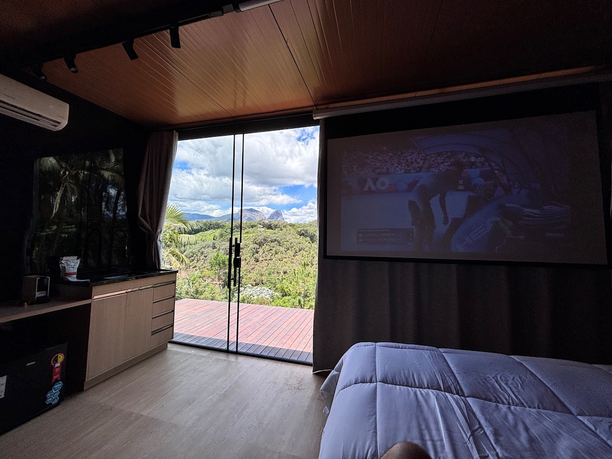 Cama com projetor descido — sessão de cinema no quarto